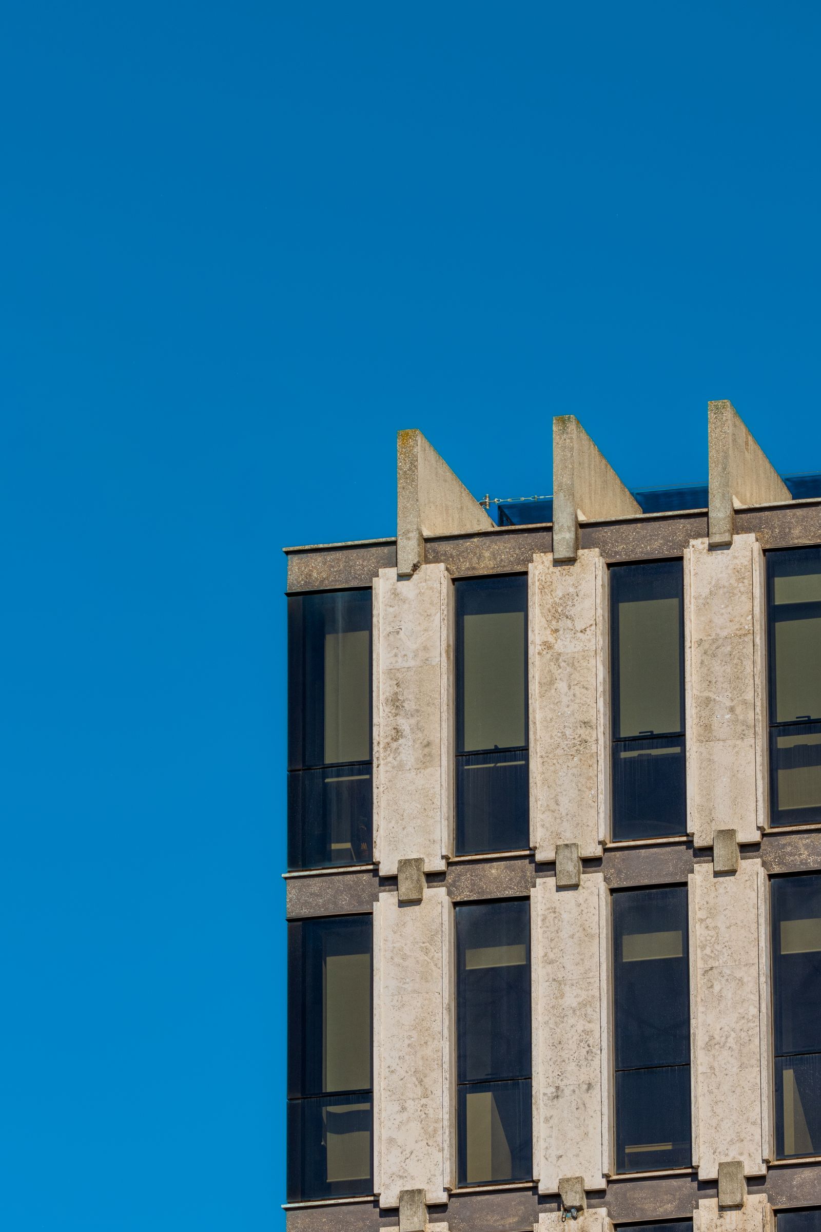 Modern building facade against clear blue sky